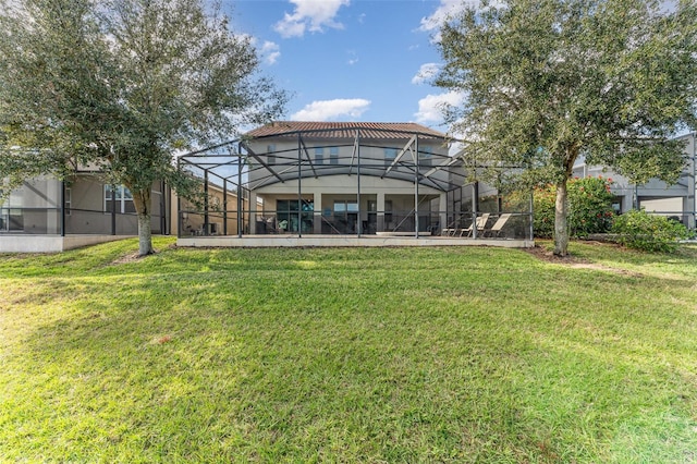 rear view of house featuring glass enclosure and a yard