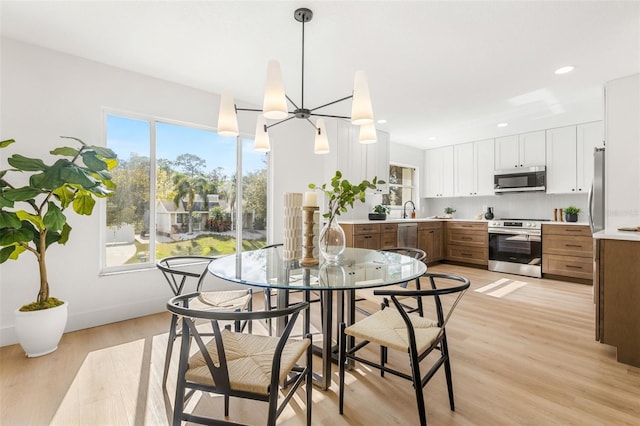 dining room with sink and light hardwood / wood-style flooring