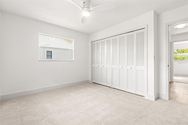 unfurnished bedroom featuring ceiling fan, light carpet, and a closet