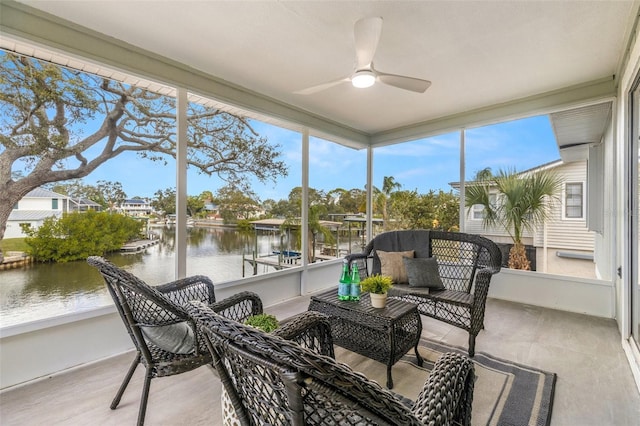 sunroom / solarium featuring ceiling fan and a water view