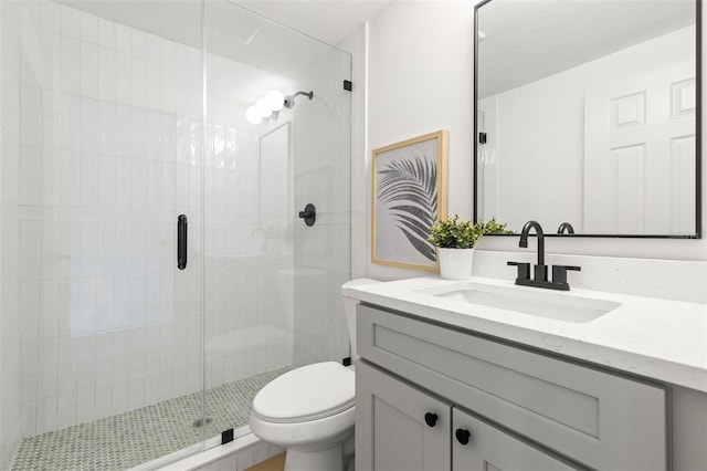 bathroom with vanity, toilet, and a shower with shower door