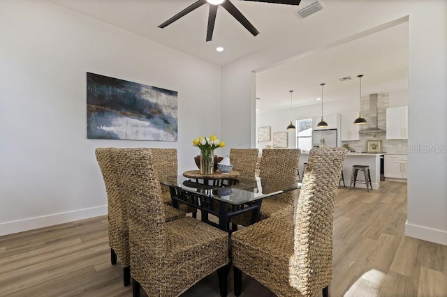 dining area featuring ceiling fan and light wood-type flooring