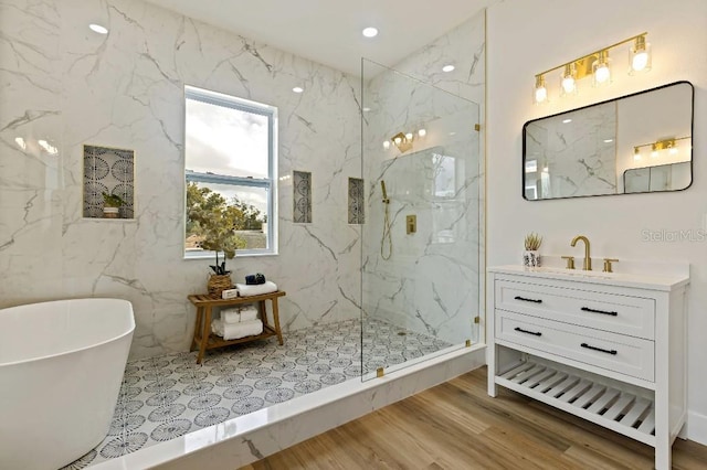 bathroom with hardwood / wood-style flooring, vanity, and shower with separate bathtub