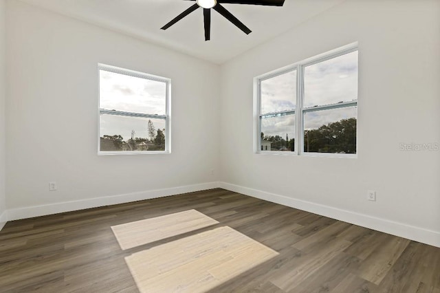 unfurnished room with dark wood-type flooring and ceiling fan