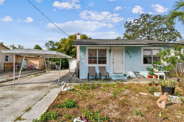 bungalow-style house featuring a carport and a shed