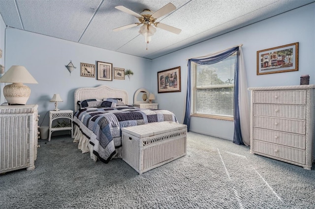 bedroom with ceiling fan, carpet floors, and a textured ceiling