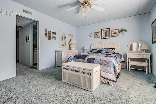 carpeted bedroom with ceiling fan and a textured ceiling