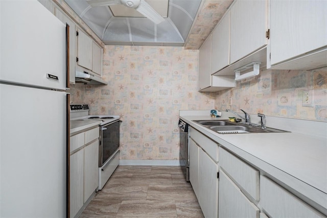 kitchen with white appliances, white cabinetry, and sink