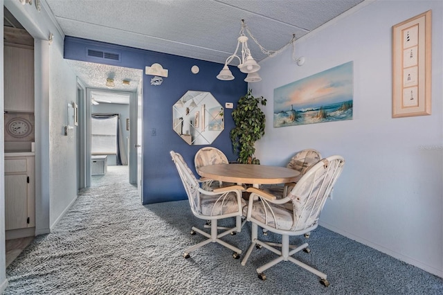dining area with visible vents, carpet flooring, a textured ceiling, and baseboards