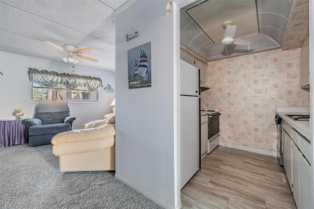 kitchen featuring freestanding refrigerator, baseboards, electric range oven, wall chimney exhaust hood, and a ceiling fan