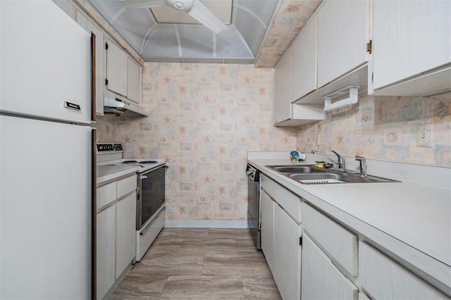 kitchen featuring a sink, white appliances, baseboards, wallpapered walls, and under cabinet range hood