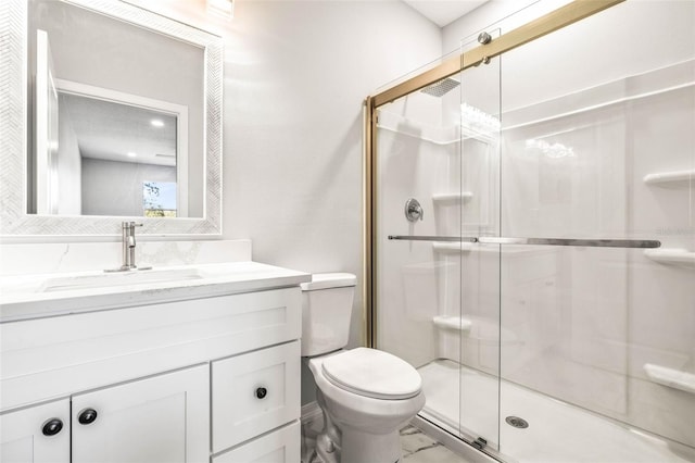 bathroom featuring vanity, toilet, and a shower with door