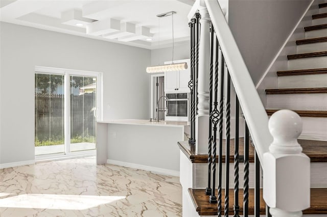 stairs with a tray ceiling, sink, and a towering ceiling