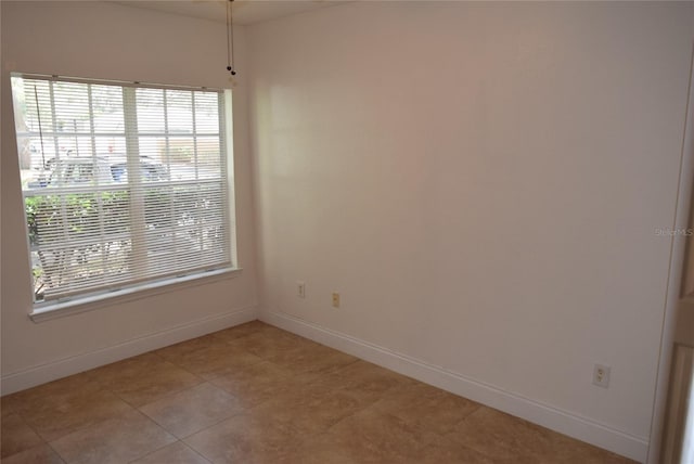 unfurnished room with baseboards and light tile patterned flooring