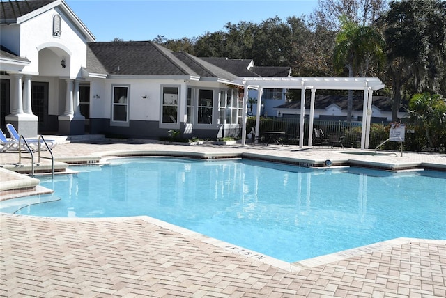 pool with a patio area, fence, and a pergola