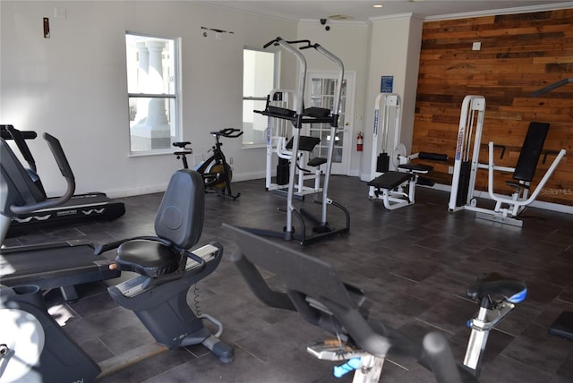 workout area with wooden walls, baseboards, and crown molding