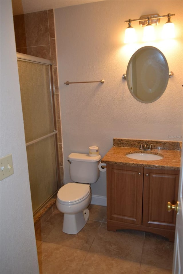 full bathroom featuring toilet, tile patterned flooring, a shower stall, and vanity