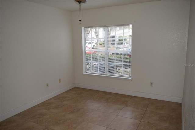 unfurnished room featuring light tile patterned floors and baseboards