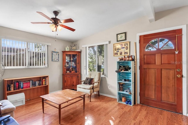 sitting room with ceiling fan, light hardwood / wood-style flooring, and beamed ceiling