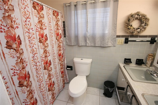 bathroom featuring toilet, tile patterned flooring, tile walls, and vanity