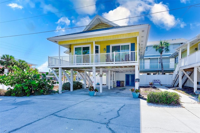 coastal inspired home featuring covered porch and a carport