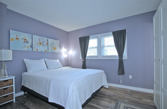 bedroom with dark hardwood / wood-style flooring