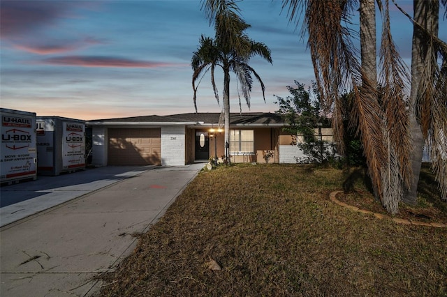 single story home featuring a yard and a garage