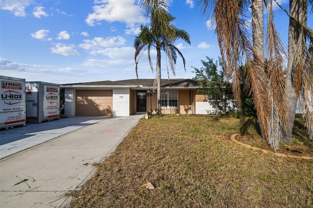 single story home featuring a garage and a front lawn