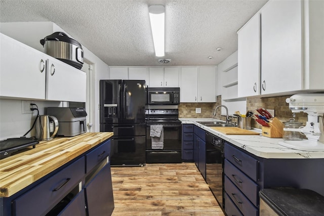 kitchen featuring black appliances, white cabinetry, sink, and blue cabinets