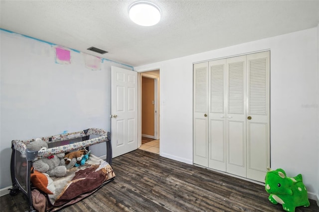 sitting room with a textured ceiling and dark wood-type flooring