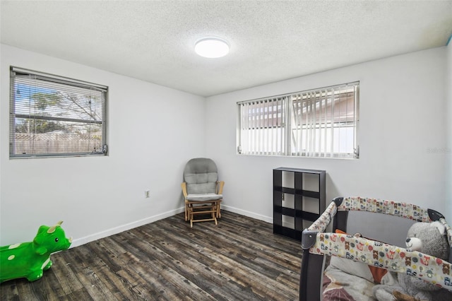 living area featuring a textured ceiling and dark hardwood / wood-style floors