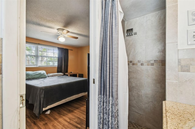 bedroom featuring hardwood / wood-style floors, a textured ceiling, and ceiling fan