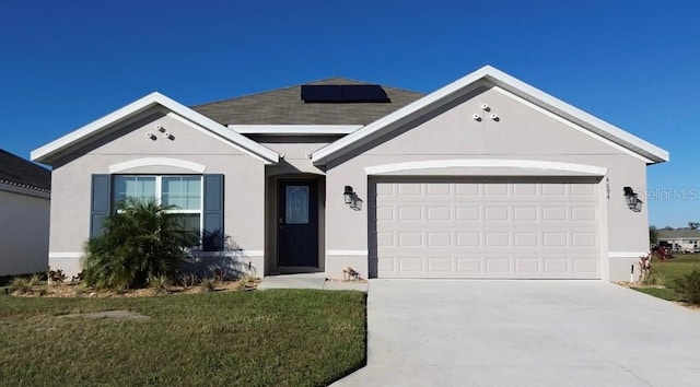 single story home with a garage, a front yard, and solar panels