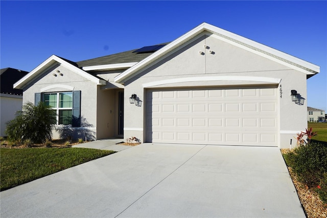 4694 Sigcom Pl, Wildwood, FL 34785 - ranch-style house featuring driveway, roof mounted solar panels, a garage, and stucco siding