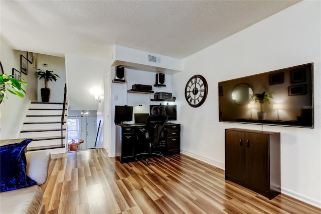 living room featuring light hardwood / wood-style flooring and a textured ceiling