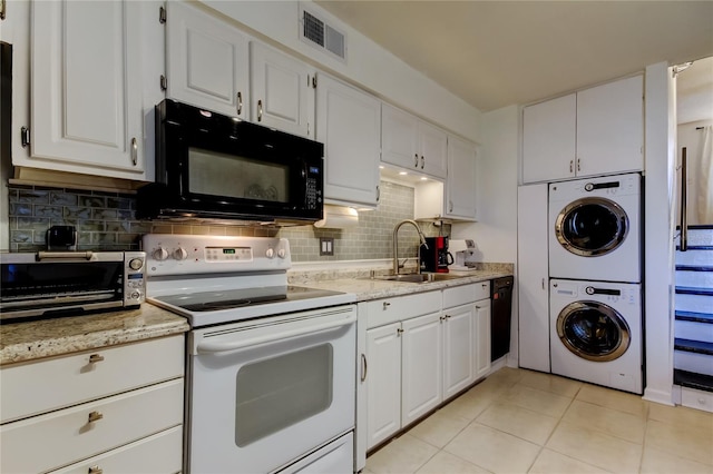 kitchen featuring stacked washing maching and dryer, sink, white cabinets, and black appliances