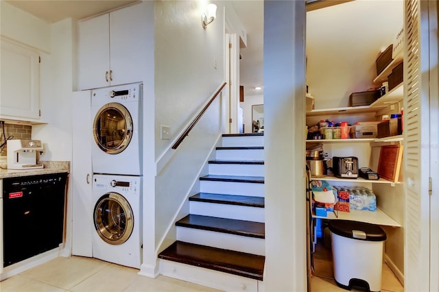 laundry area featuring stacked washer and clothes dryer and light tile patterned floors