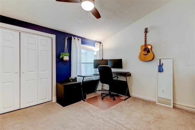 carpeted home office with ceiling fan, vaulted ceiling, and a textured ceiling