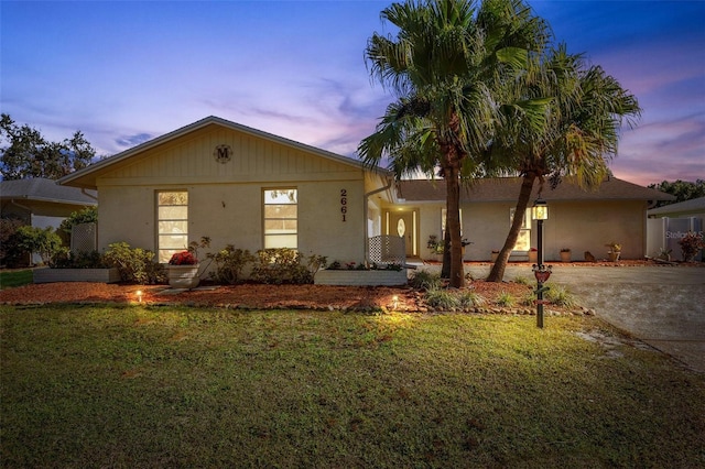 ranch-style home with a lawn