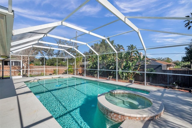 view of swimming pool with glass enclosure, an in ground hot tub, and a patio