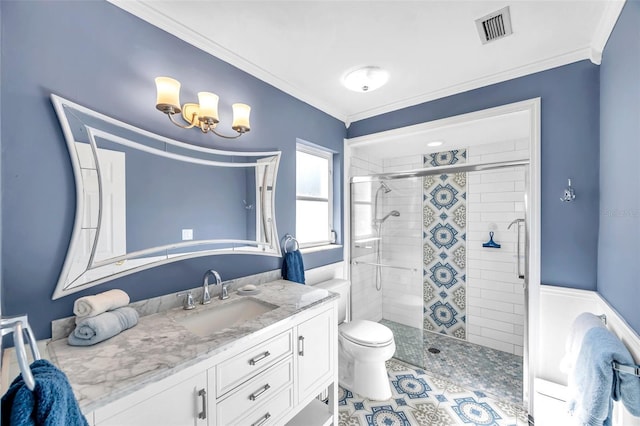 bathroom featuring crown molding, vanity, a shower with shower door, and toilet