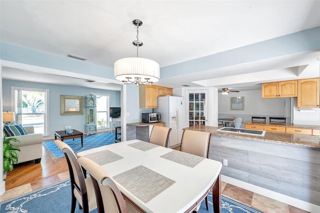 dining area featuring ceiling fan with notable chandelier