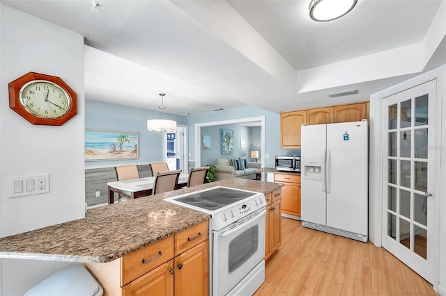 kitchen featuring white appliances, an inviting chandelier, light hardwood / wood-style flooring, dark stone countertops, and decorative light fixtures