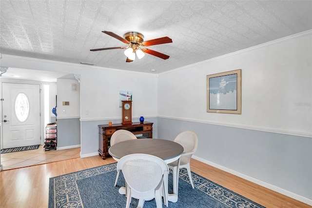 dining space featuring ceiling fan, light hardwood / wood-style floors, and ornamental molding