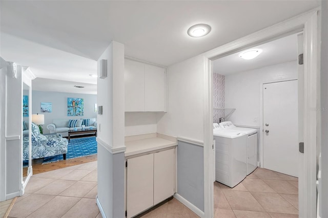 washroom with independent washer and dryer and light tile patterned floors