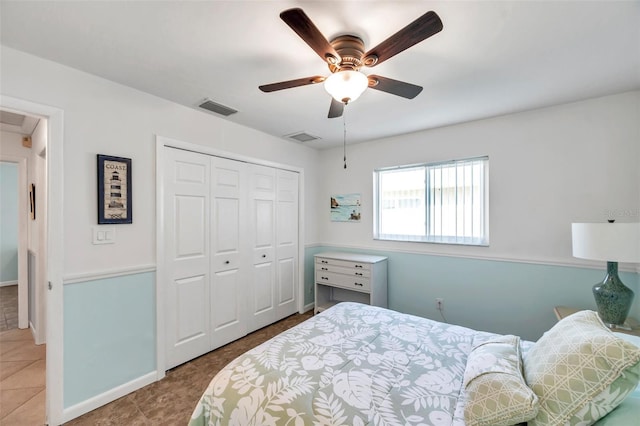 tiled bedroom with ceiling fan and a closet