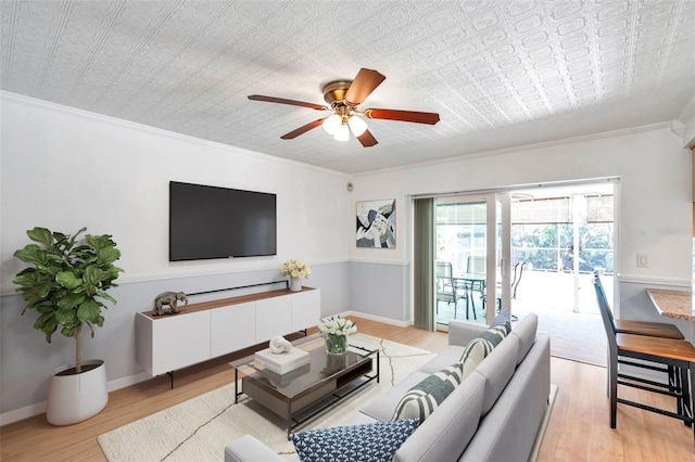 living room featuring light hardwood / wood-style flooring, ceiling fan, and ornamental molding