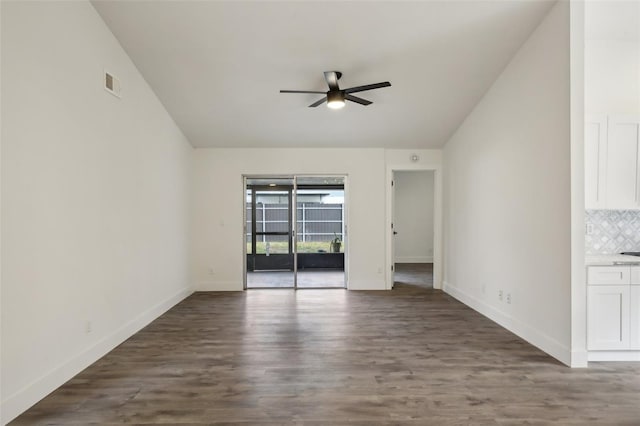 unfurnished living room with vaulted ceiling, ceiling fan, and dark wood-type flooring