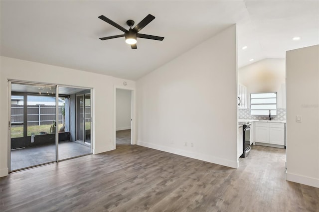 unfurnished living room featuring ceiling fan, lofted ceiling, and light wood-type flooring