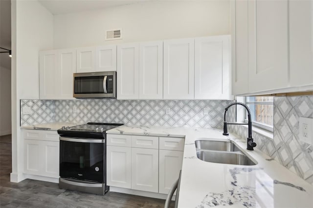 kitchen featuring white cabinets, backsplash, sink, and stainless steel appliances